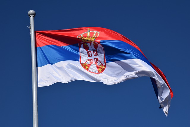A Serbian flag with blue sky in the background