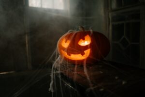 A jack-o-lantern covered in spider web.
