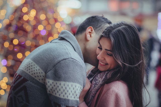 A boy and a girl hugging, he's kissing her cheek and she's smiling.(Learn Serbian online flirting tricks and find your soulmate!)
