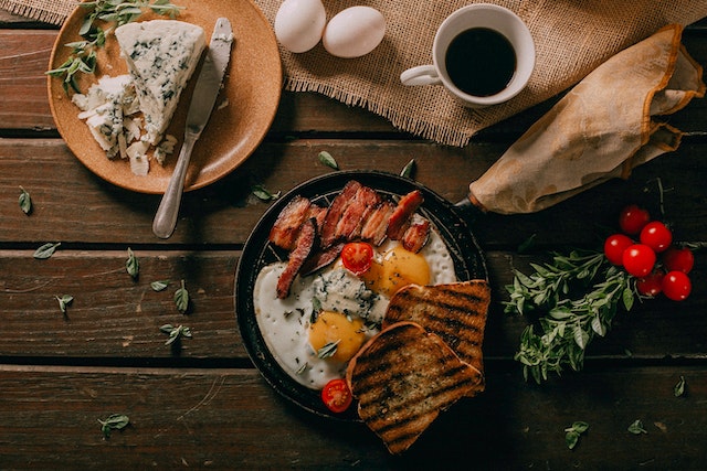 A meal with toast, eggs, bacon, cheese, tomatoes, and coffee.
(Learning Serbian false friends some would consider this meal with paradajz a paradise!)