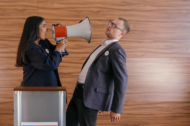 A woman yelling at a man with a megaphone.
(Learning Serbian false friends: you need arguments in an argument!)