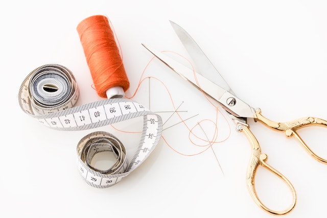 Scissors, tape measure and an orange thread on the white table.
(If you want lessons tailored to your specific needs, don't opt for a Serbian online course!)