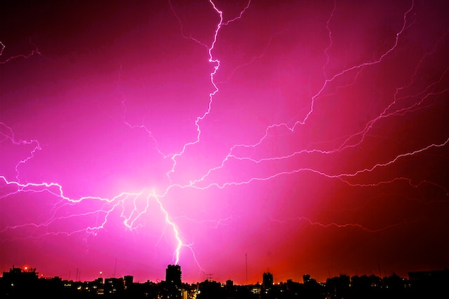 Serbian lessons for foreigners: A pink sky with lightning bolts above the city.