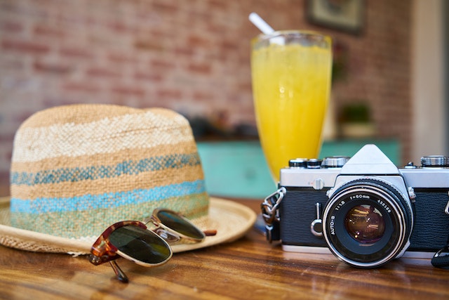 A hat, sunglasses, a yellow cocktail, and a camera.
(What would you bring for a vacation in Serbia?)
