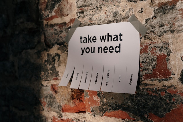 A paper on the wall. It's written: "Take what you need", and then there are cut pieces of paper saying: "money", "love", "courage", "luck", "happiness", "hope", and "passion".
(Do you know to write this in Serbian?)
